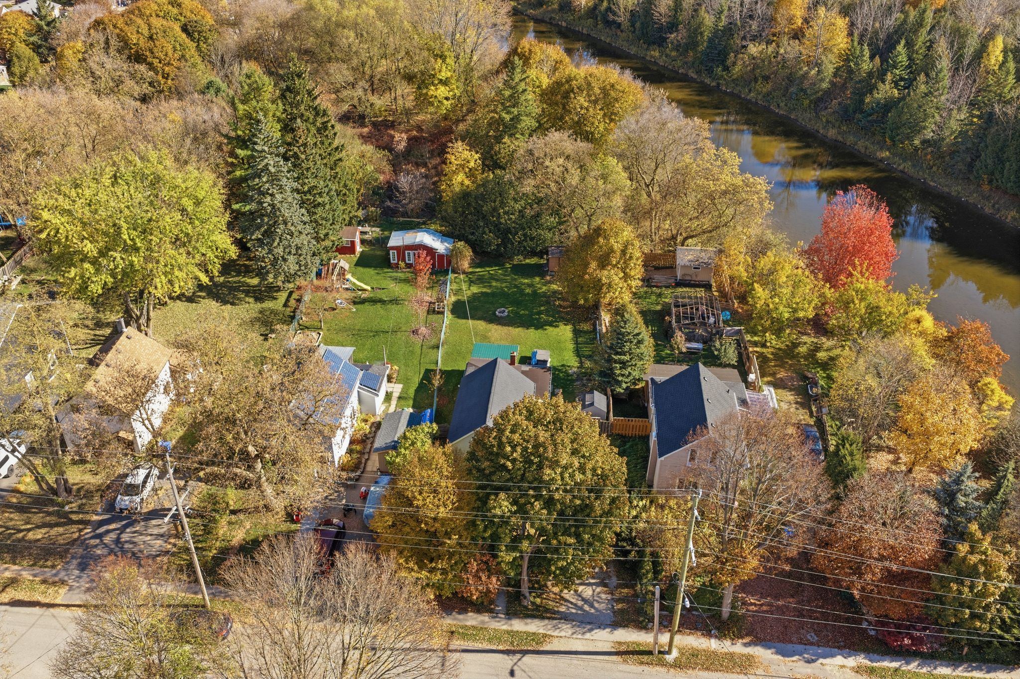 Aerial view of homes backing onto the Grand River in Grand Valley in autumn