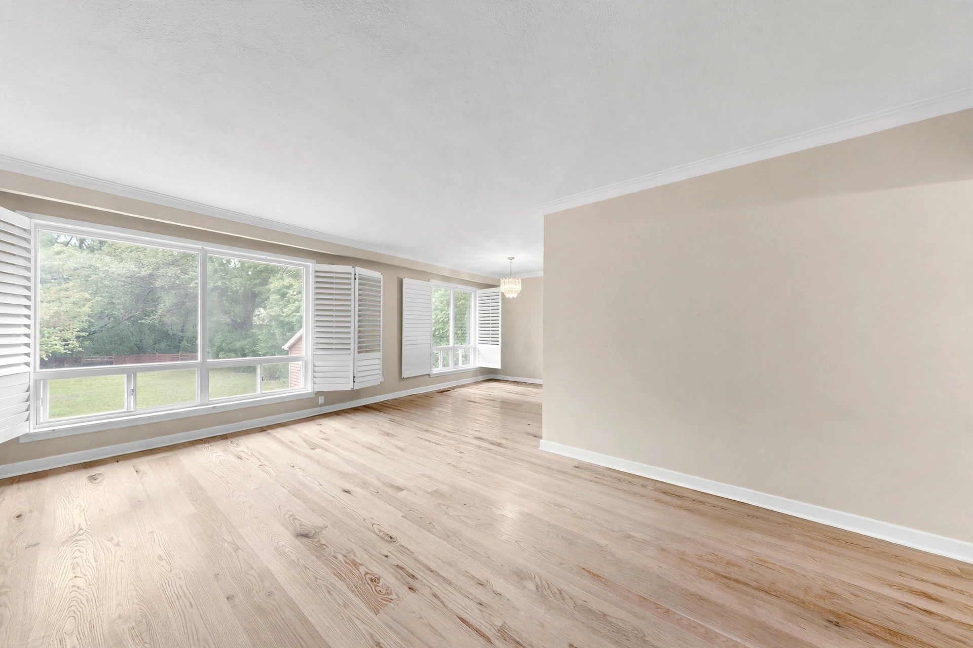 Bright living room with hardwood floors and plantation shutters