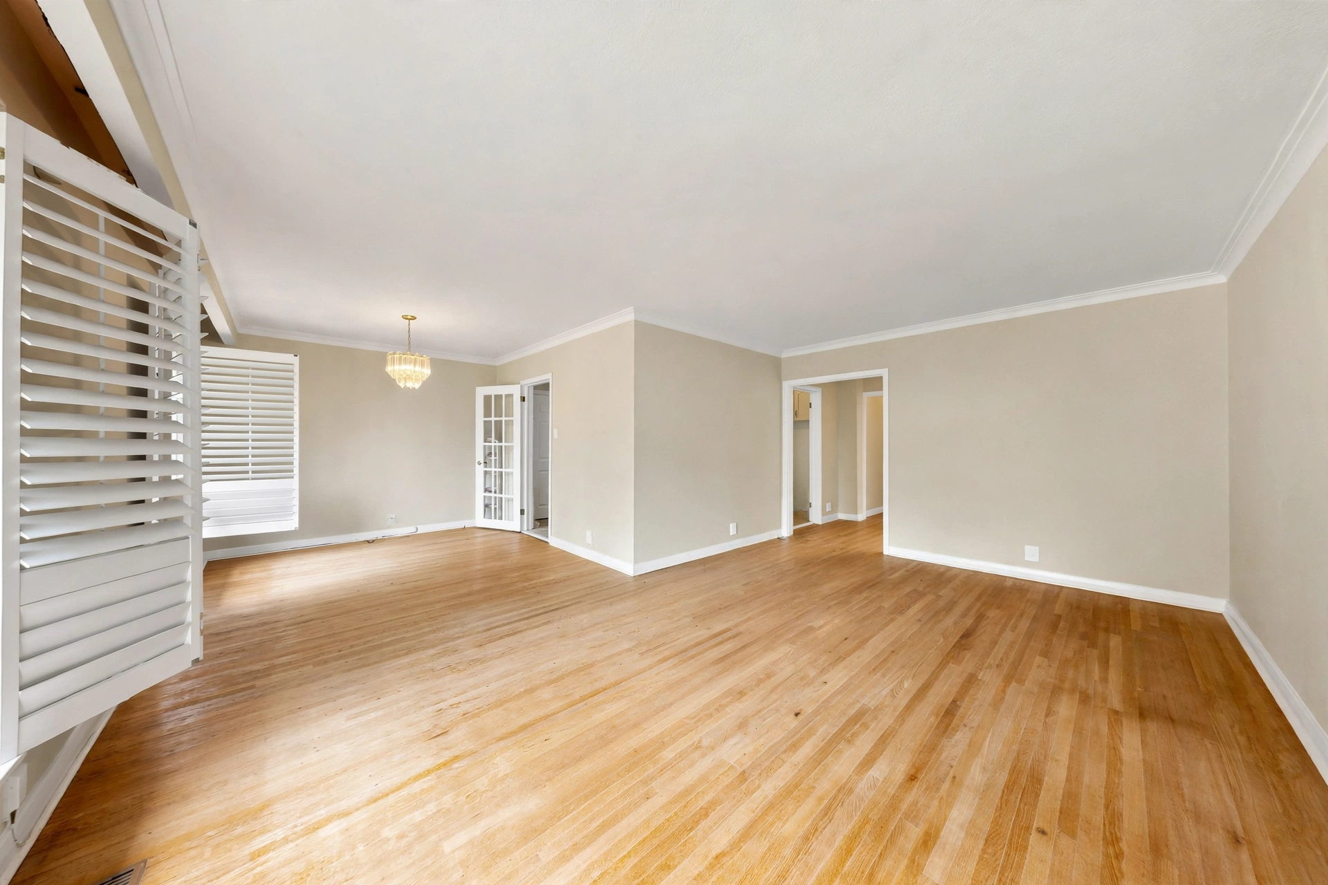 Open living and dining room with hardwood floors and plantation shutters at 35 Florens Avenue, Toronto