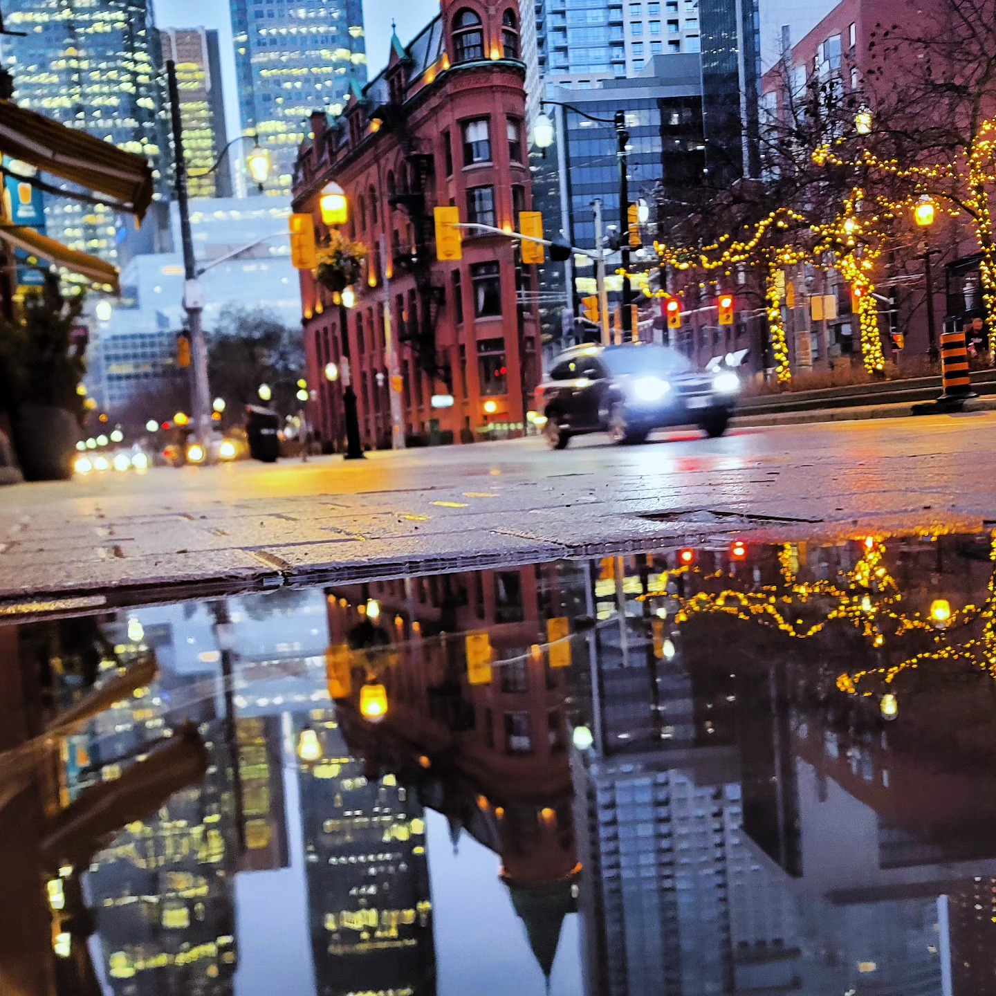 The Gooderham Building reflected in a puddle at Front and Church, Toronto