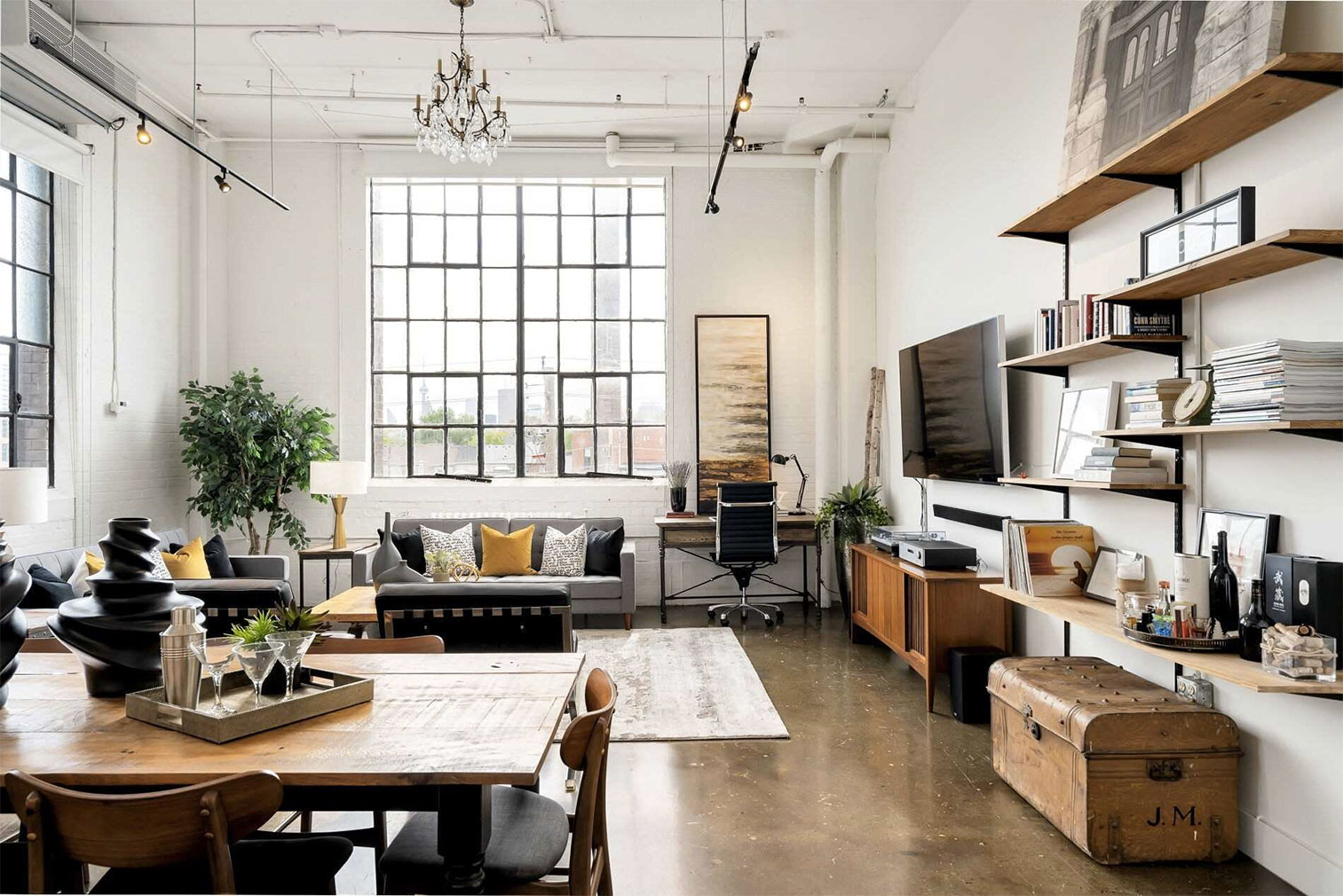 Sunlit hard loft interior at Wrigley Lofts, 245 Carlaw Ave, with oversized warehouse windows and concrete floors