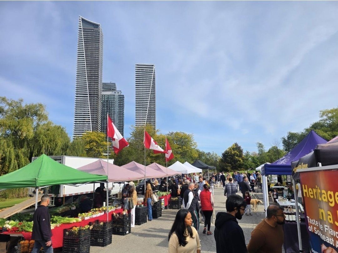 Market aisle with the Eau du Soleil condo towers behind the vendor tents