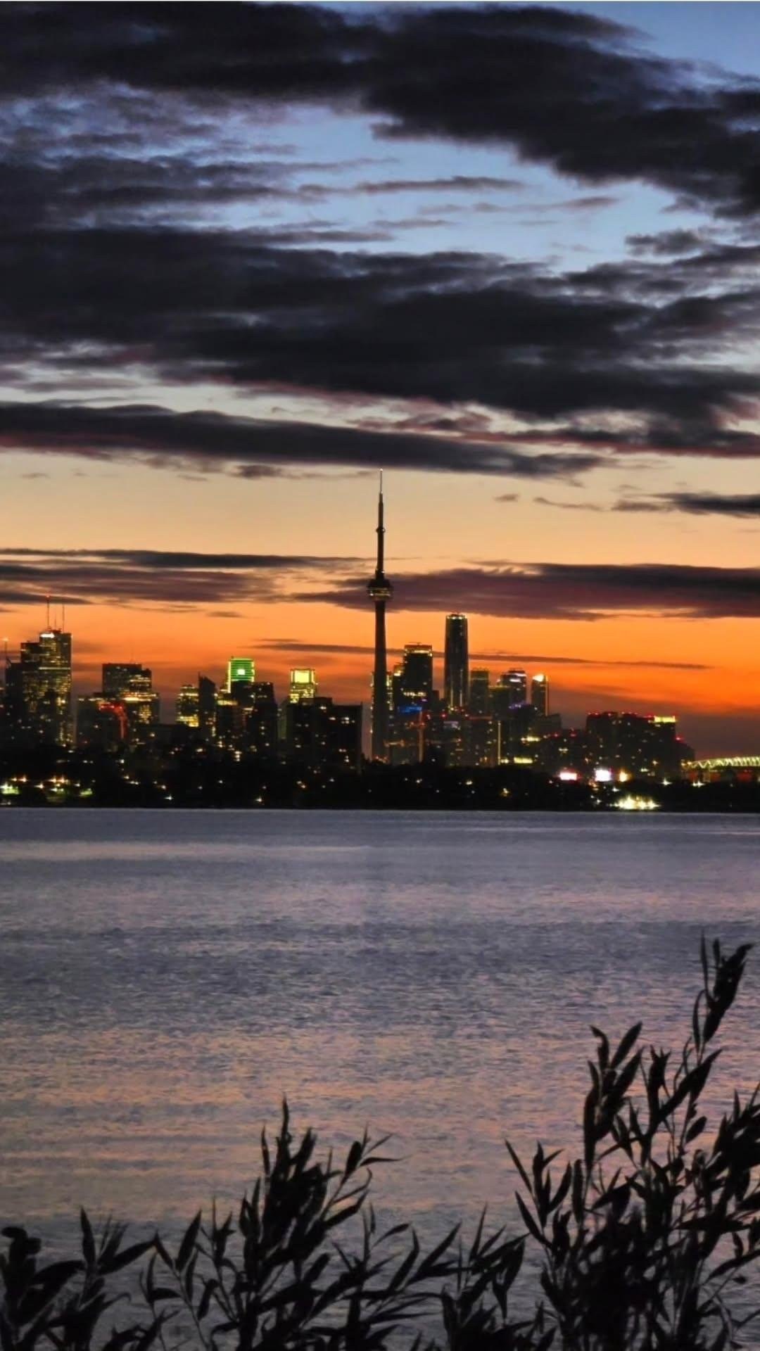 Toronto skyline at sunrise with the CN Tower, seen across the water from Humber Bay Shores