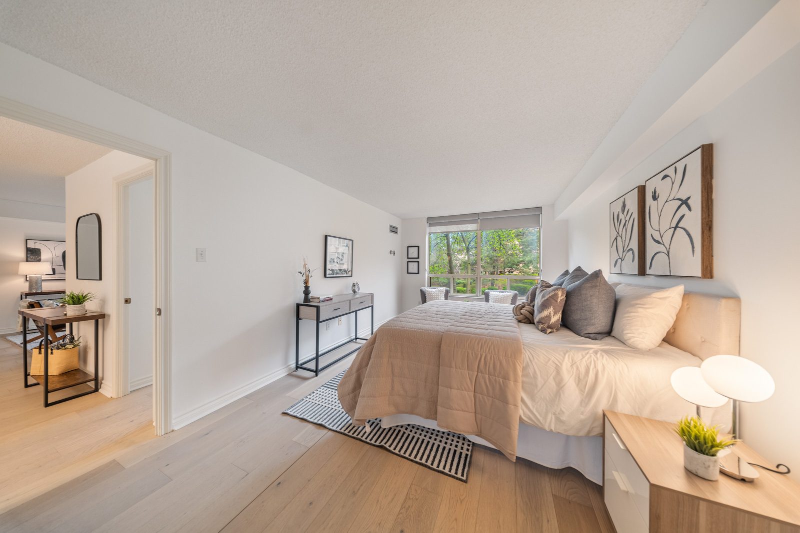 Staged bedroom with a large window wall at 1200 Don Mills Road, Toronto