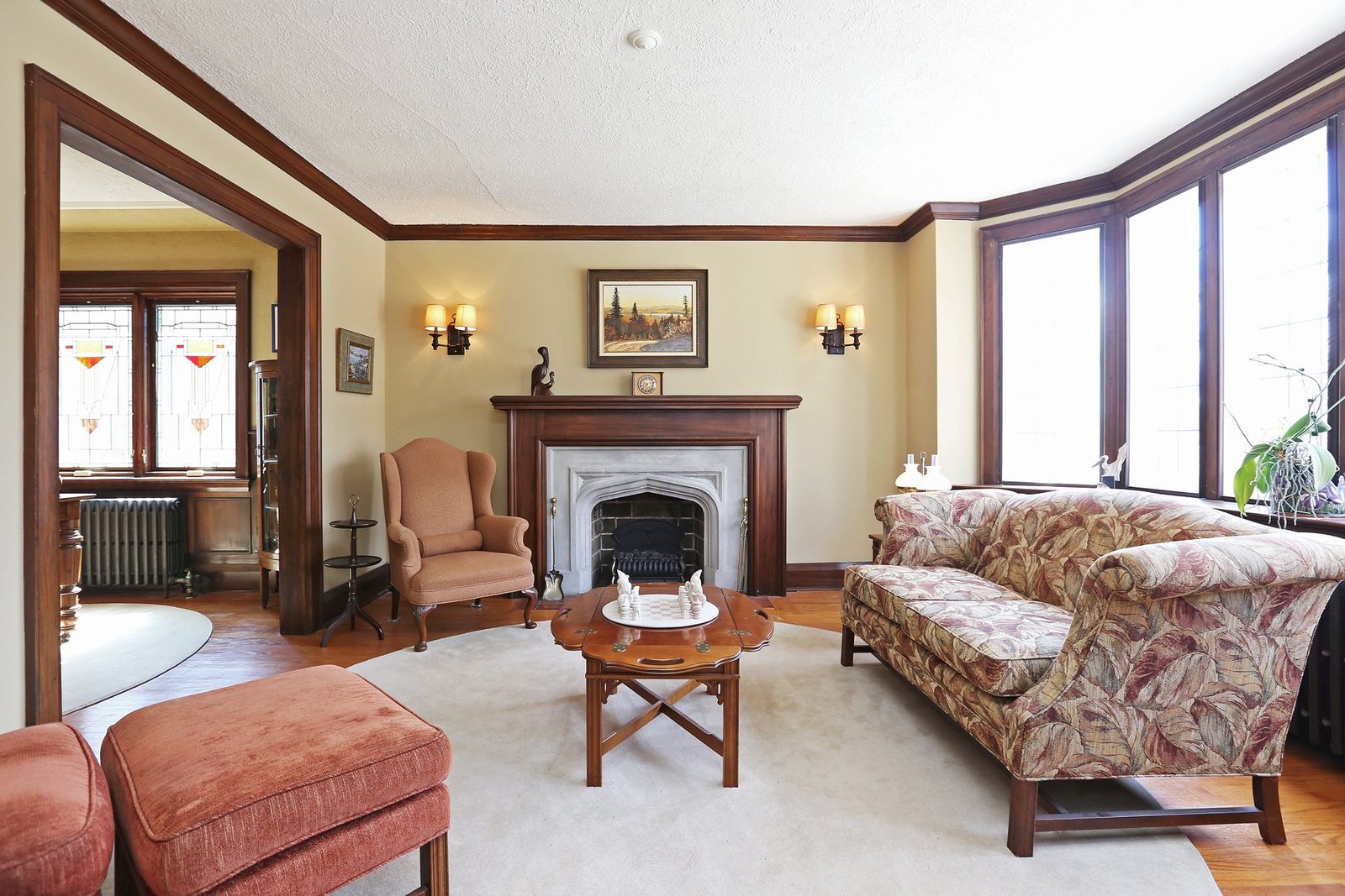 Staged traditional living room with a floral sofa and fireplace at 17 Courcelette Road in the Beach, Toronto