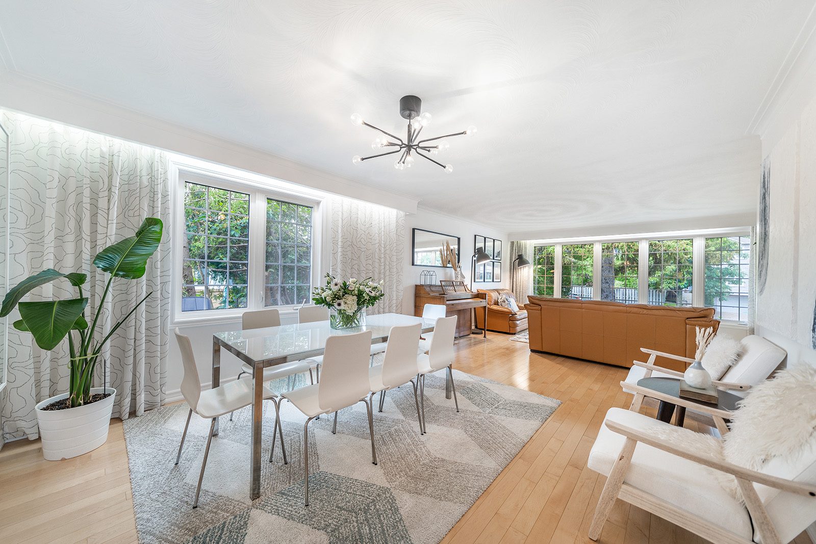 Staged dining area with a glass table opening into the living room at 177 Clanton Park Road, Toronto