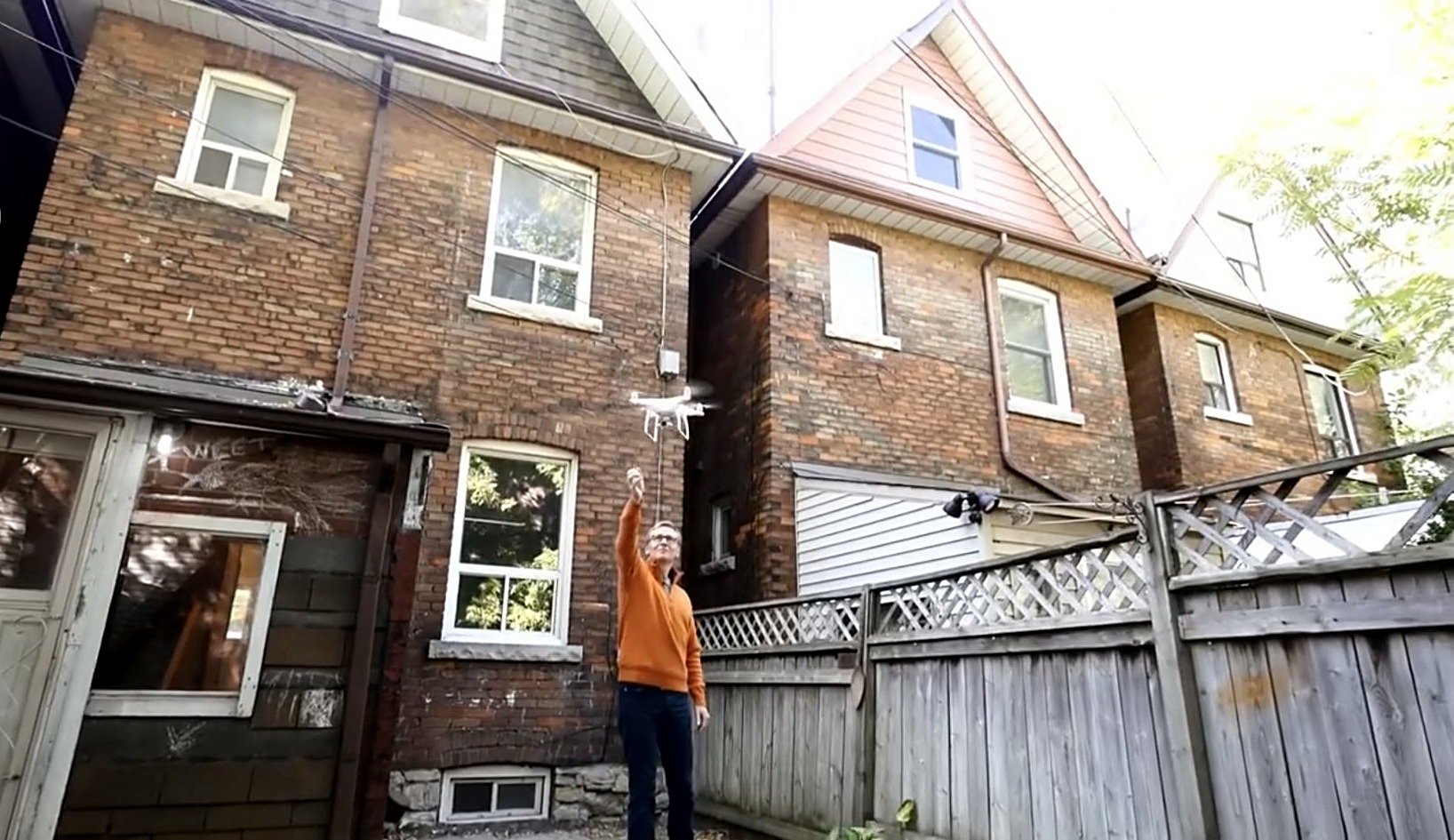 Jim Emilson launching a drone into the air over the 2016 Runnymede Avenue listing