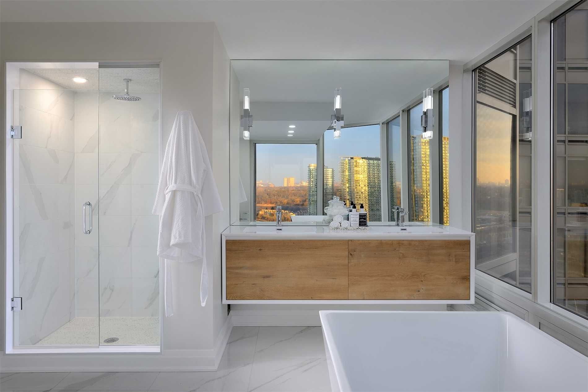 The bathroom at 2201 - 1 Palace Pier Court — glass walk-in shower and double vessel-sink vanity with city views