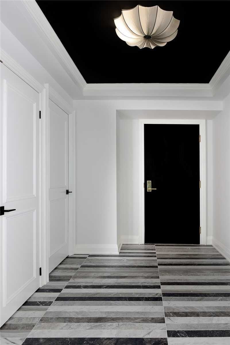 The entry foyer at 2201 - 1 Palace Pier Court — black ceiling, sculptural light fixture and striped marble floor