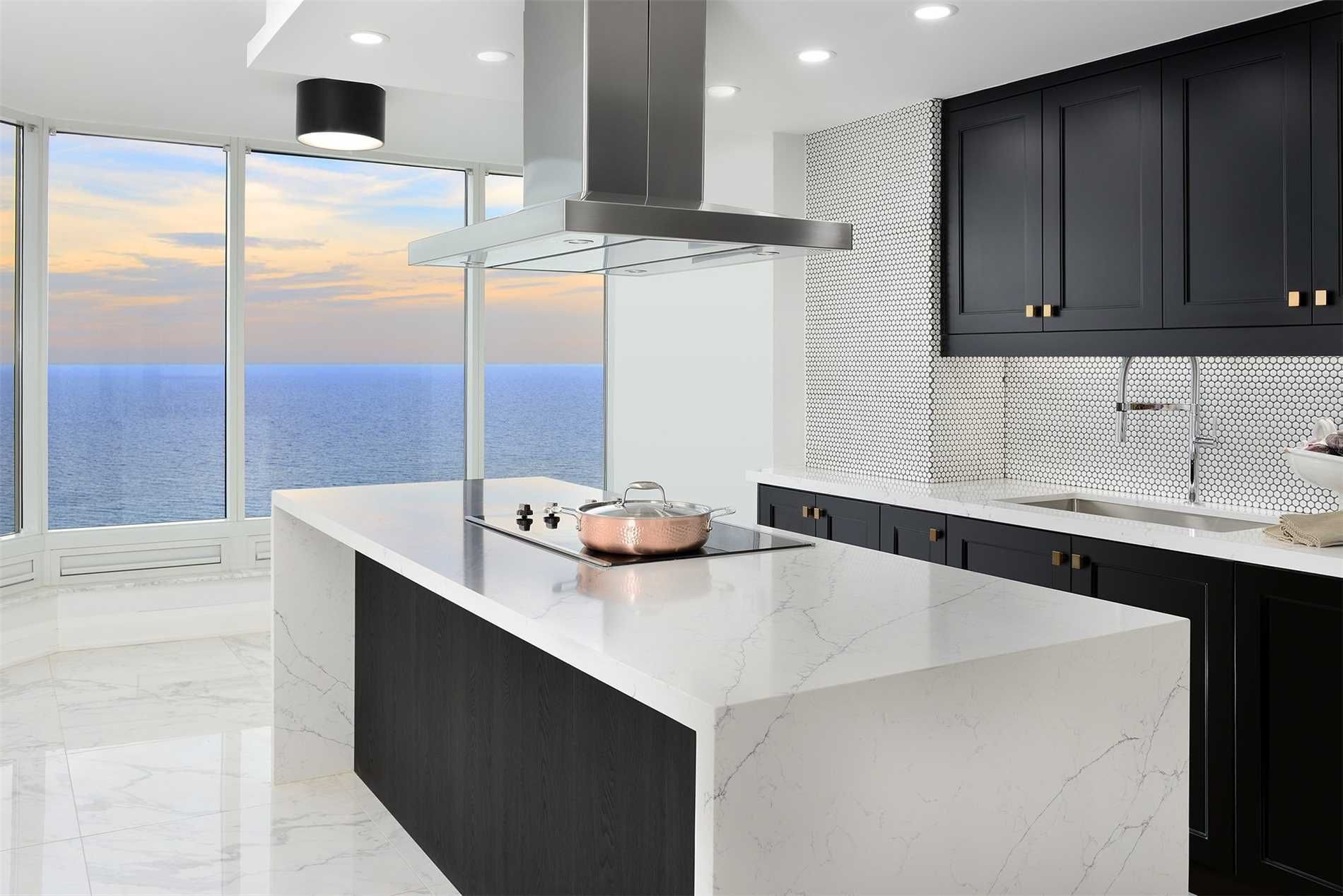 The kitchen at 2201 - 1 Palace Pier Court — waterfall island with cooktop in front of panoramic lake-view windows