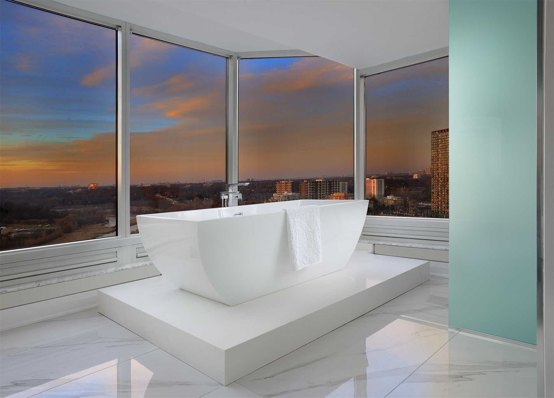 The ensuite at 2201 - 1 Palace Pier Court — freestanding soaker tub in front of curved windows at sunset