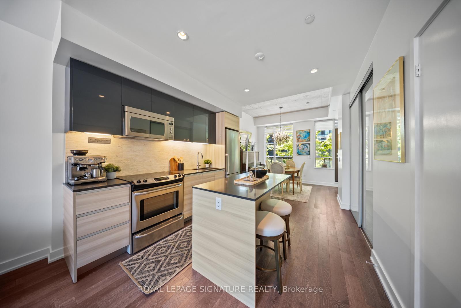 Modern kitchen with dark cabinetry, quartz counters and island with breakfast bar at Suite 331