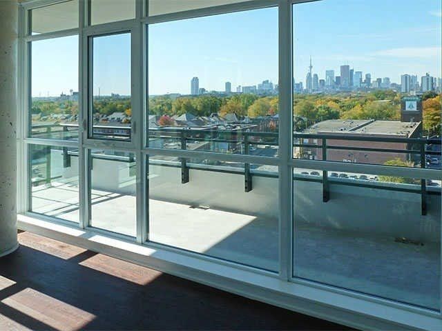 Corner wall of floor-to-ceiling windows at Unit 914 with the Toronto skyline and CN Tower in the distance