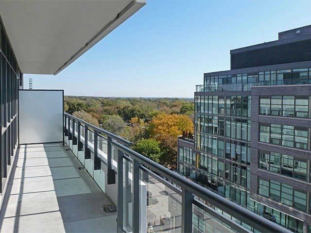 The 270 sq ft wrap-around balcony at Unit 914, overlooking the buildings and tree canopy of Leslieville