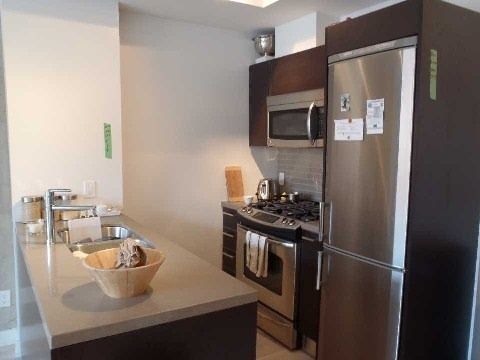 Modern kitchen at Unit 306 with stainless steel gas range, fridge, and microwave