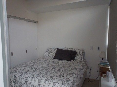 Bedroom at Unit 306 with hardwood floors and wall-to-wall closet doors
