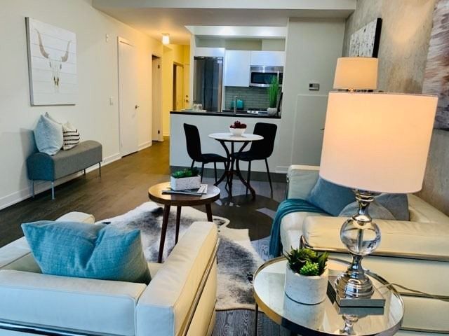 Open-concept living and dining area at Unit 901 with view through to the stainless steel kitchen