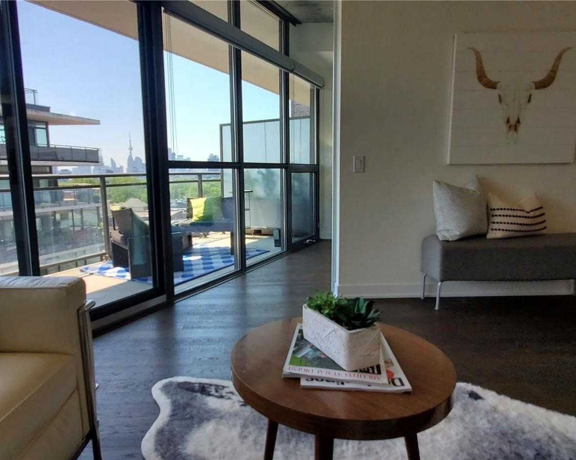 Living room at Unit 901 opening through floor-to-ceiling doors to the balcony with downtown views