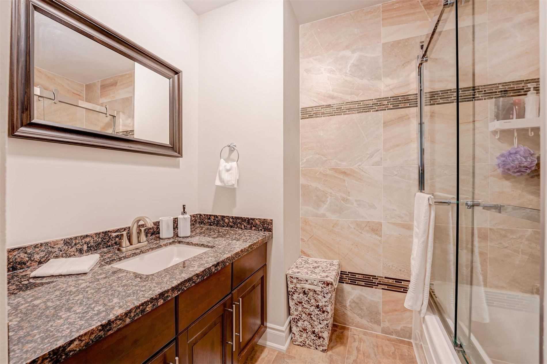 Bathroom with glass walk-in shower and marble-look tile