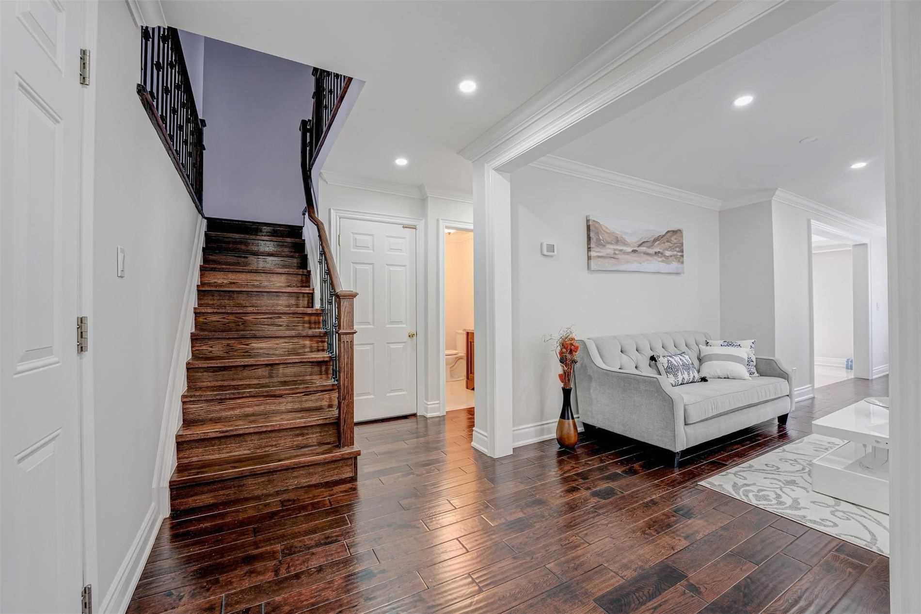 Entry hall with oak staircase and dark hardwood floors