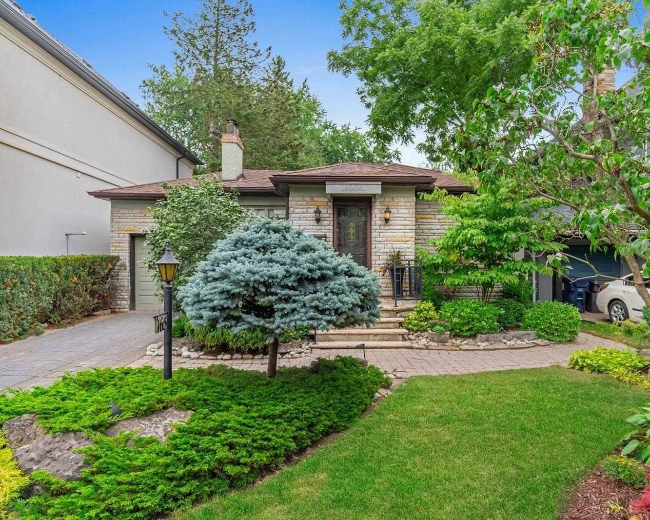 Manicured front garden with mature trees at 165 The Kingsway
