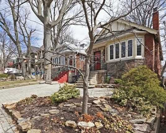 Front exterior of the brick bungalow at 17 Courcelette Road, Toronto, with interlocked private drive