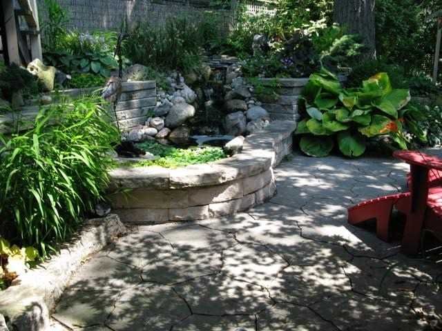Stone patio by the pond in summer at 17 Courcelette Road, Toronto