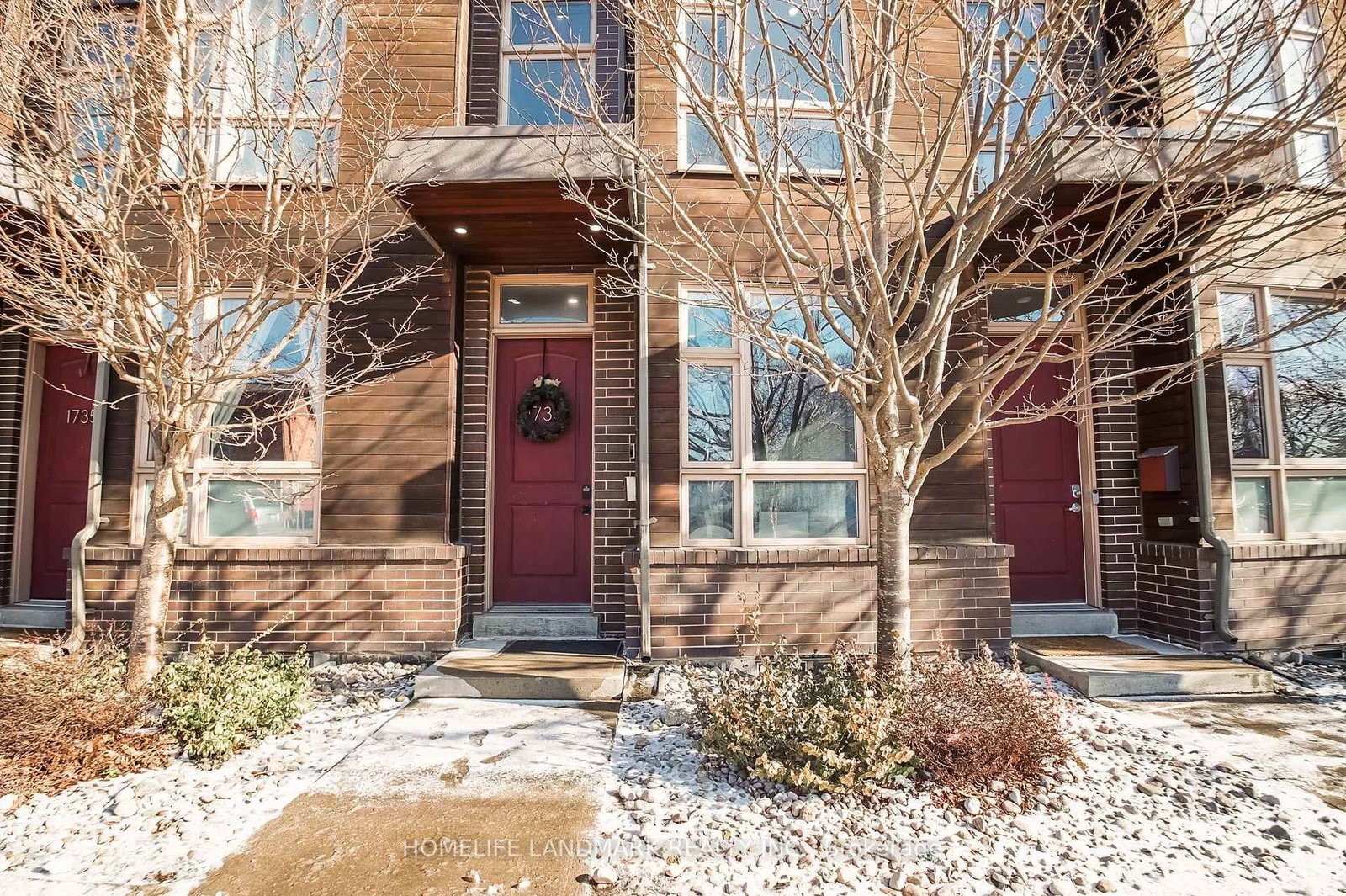 The front of 1733 Kingston Road, Toronto — modern townhome facade with brick, wood accents and a red front door