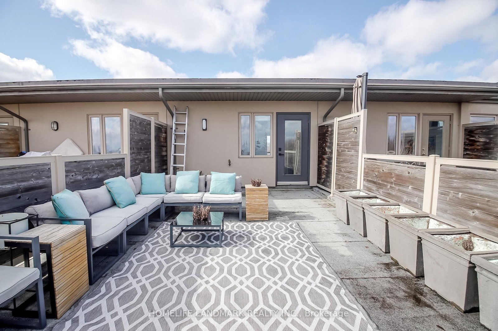 The rooftop terrace at 1733 Kingston Road — furnished lounge area with an outdoor sectional, coffee table and planters