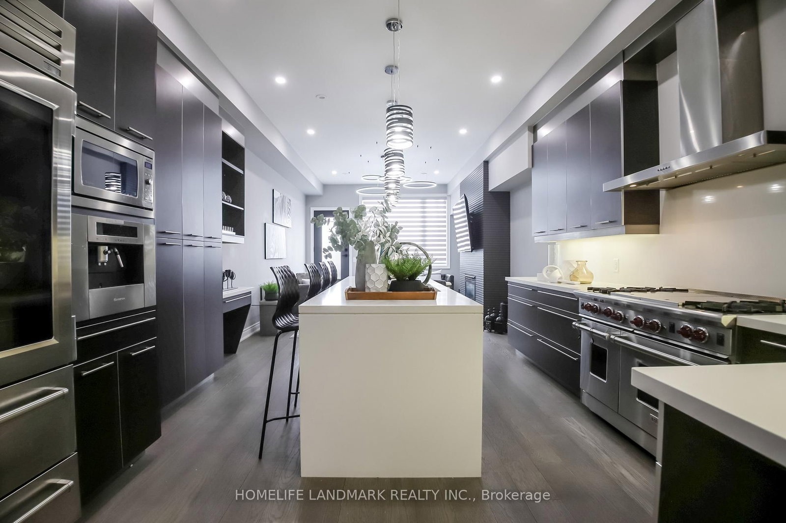The gourmet kitchen at 1733 Kingston Road — Wolf range, dark cabinetry, island and stainless steel Sub-Zero refrigerator