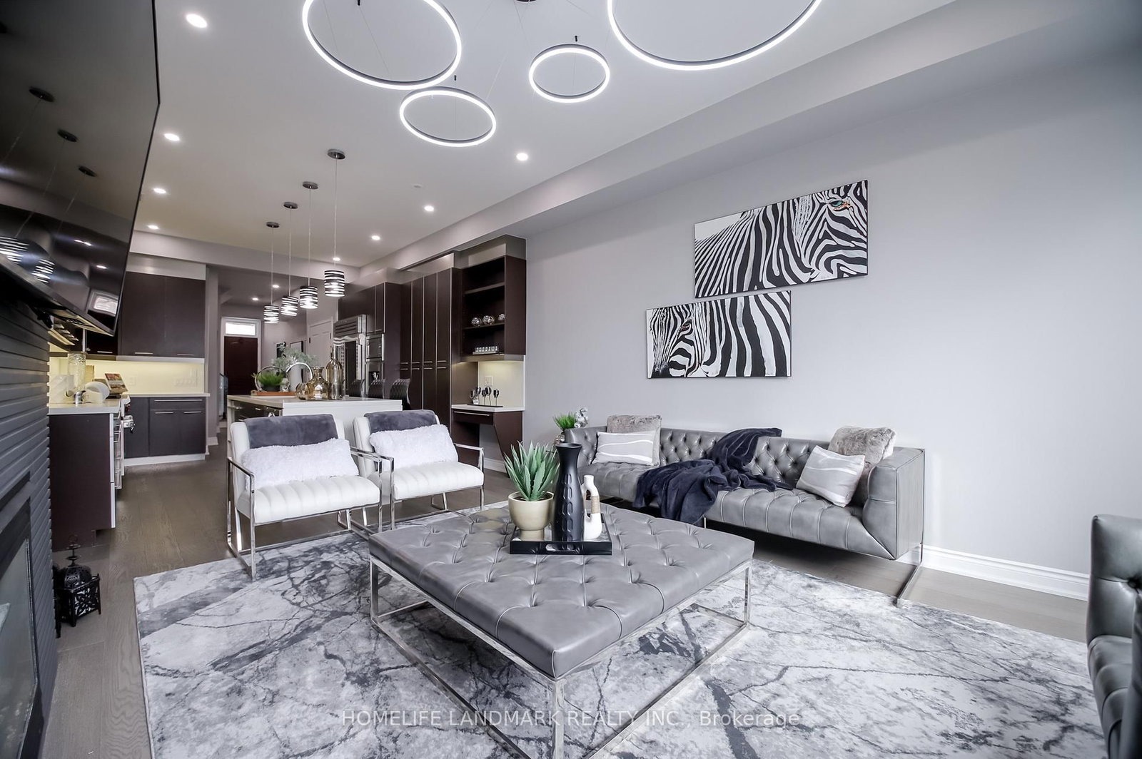 The living room at 1733 Kingston Road — gas fireplace, statement zebra artwork and sculptural ceiling lights