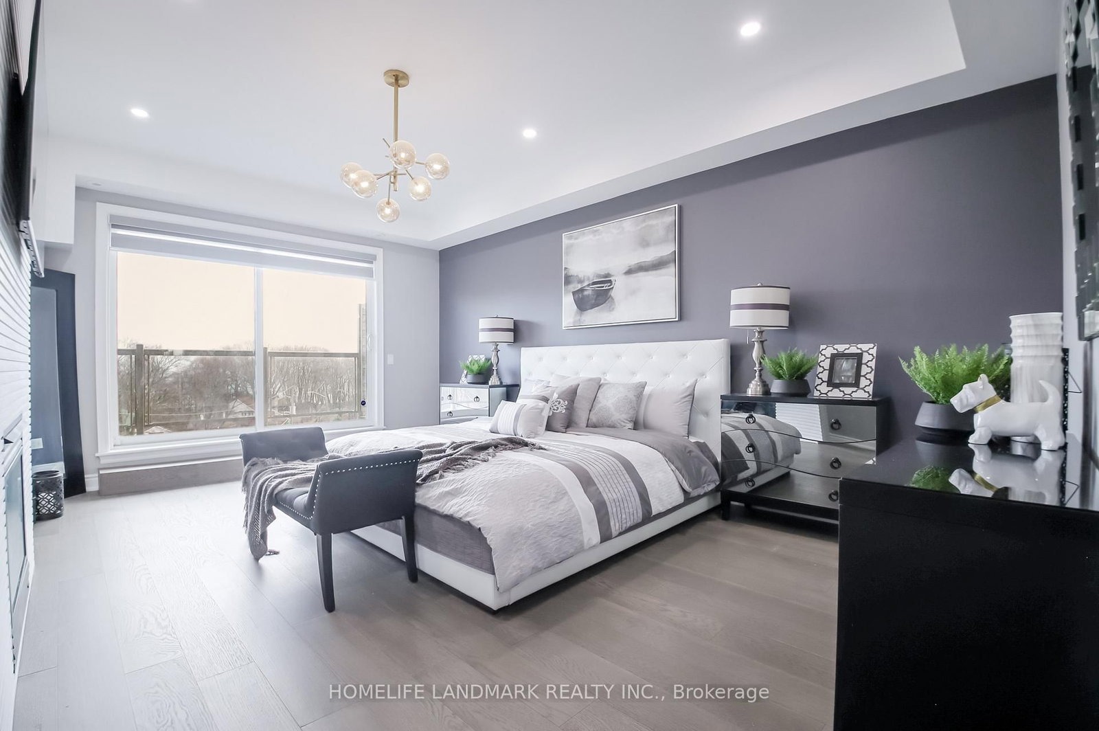 The primary bedroom at 1733 Kingston Road — plush bedding, chandelier and broad windows over the neighbourhood