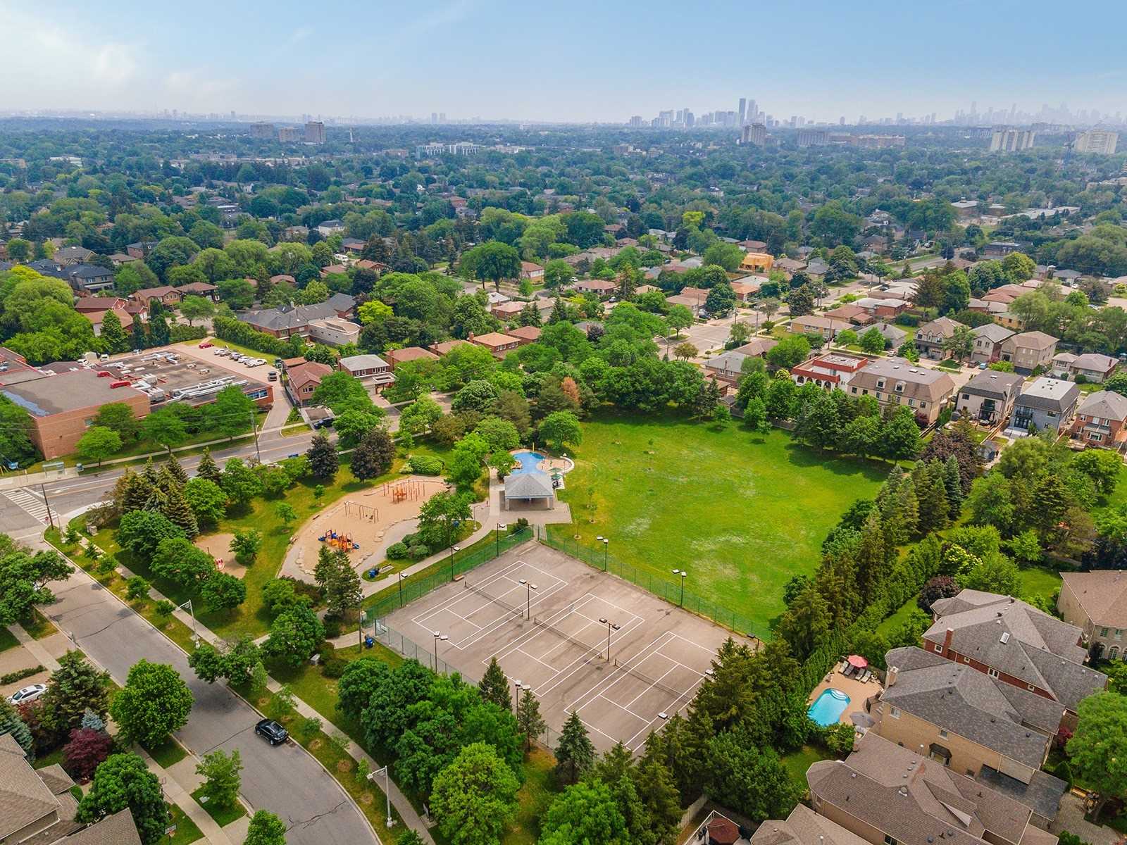 Aerial view of the Clanton Park neighbourhood with parks, tennis courts, and the Toronto skyline