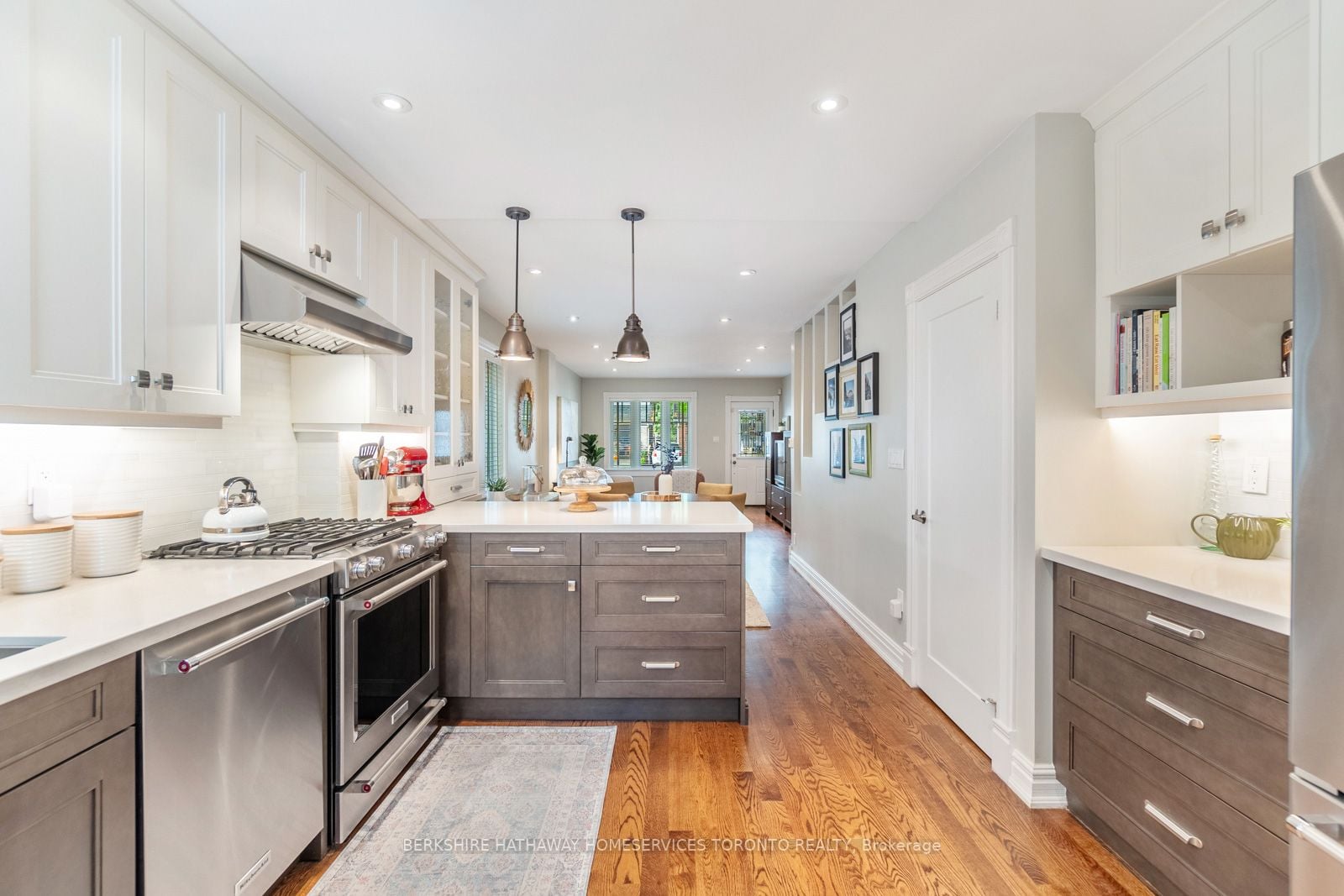 Main kitchen with island, pendant lights, gas range, and open view to the living room