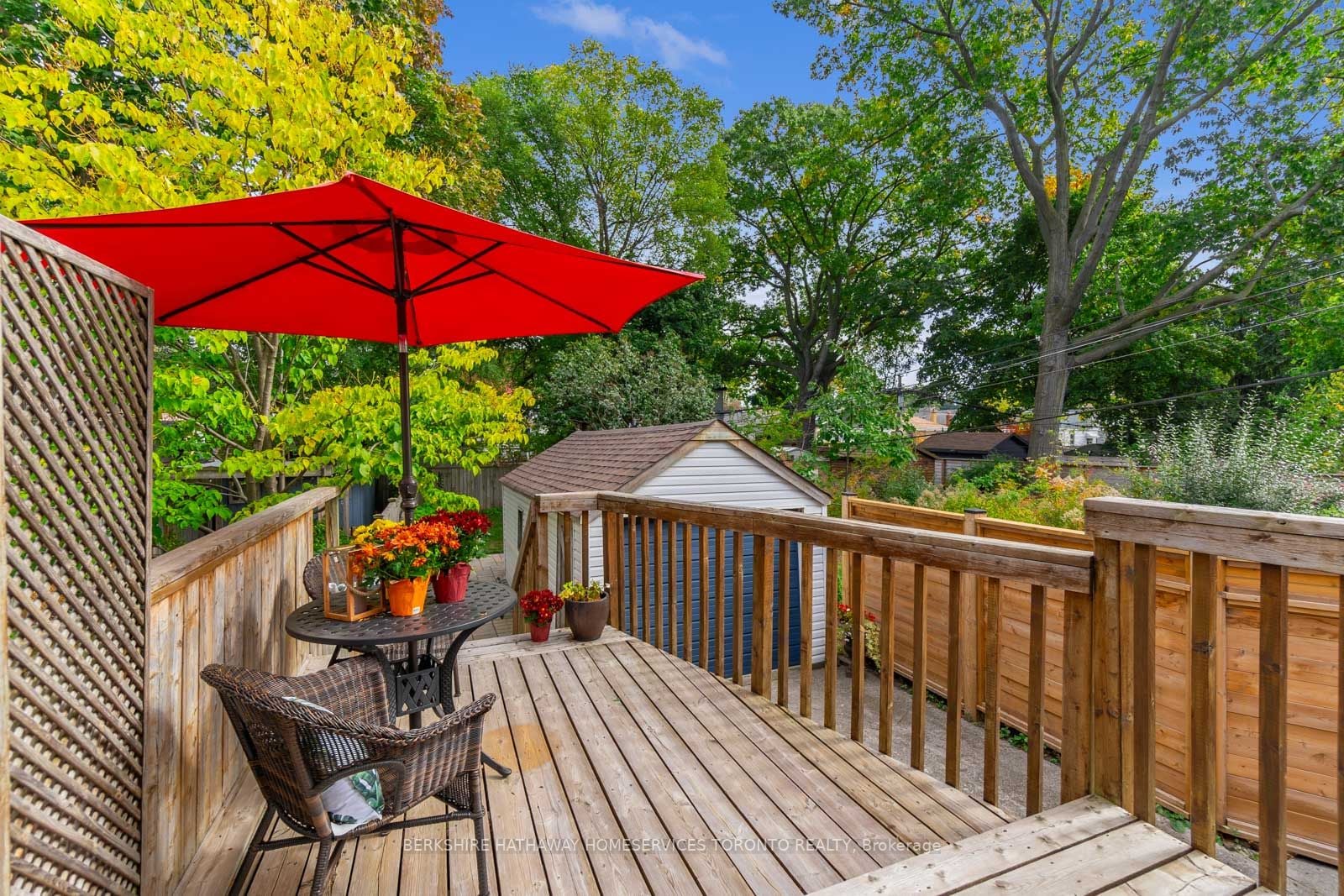 Rear deck at 193 Lawlor Avenue with red umbrella, patio furniture, and the detached garage beyond