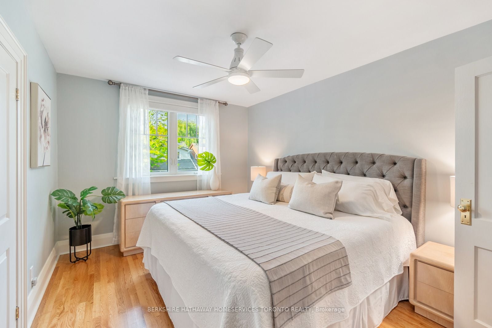 Primary bedroom at 193 Lawlor Avenue with tufted headboard, ceiling fan, and hardwood floors