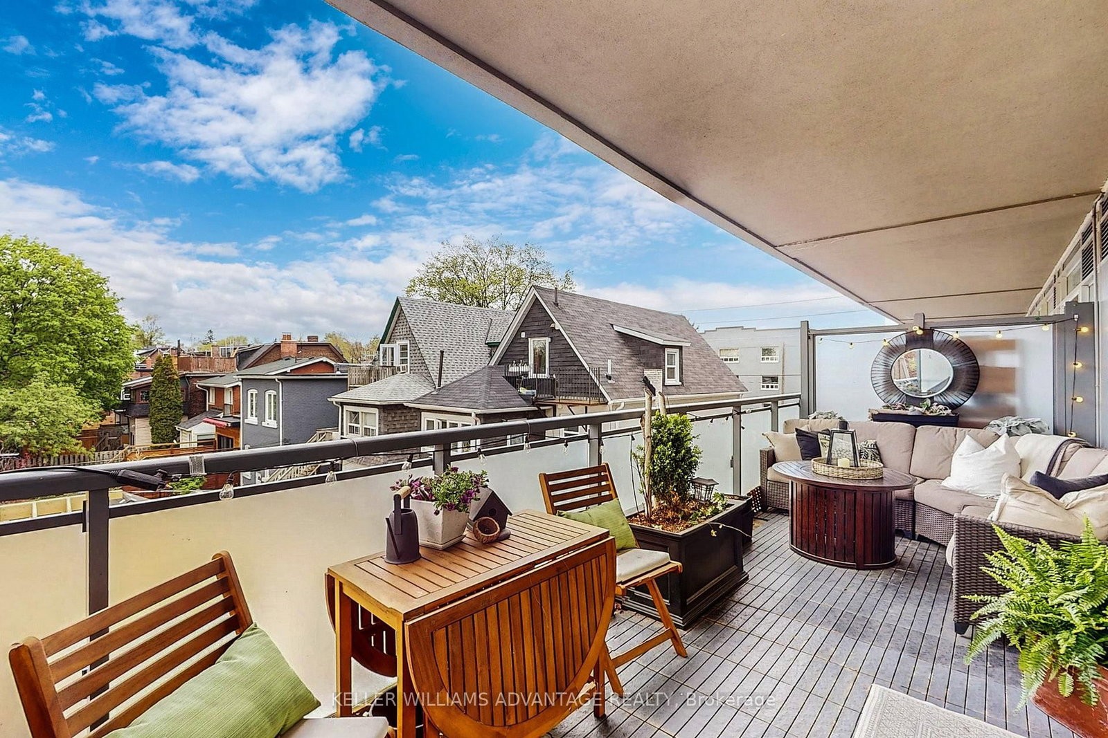 The rooftop terrace at 308 - 200 Woodbine Avenue, Toronto — lounge seating, patterned rug and lake views over the Beaches