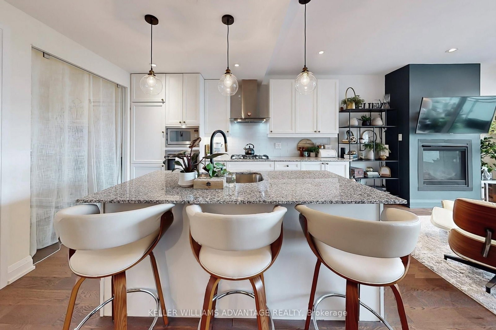 The kitchen island at 308 - 200 Woodbine Avenue — granite counters and bar stools