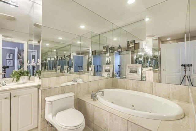 The ensuite at 1709 - 2111 Lake Shore Blvd W — jacuzzi spa tub with marble surround and mirrored walls