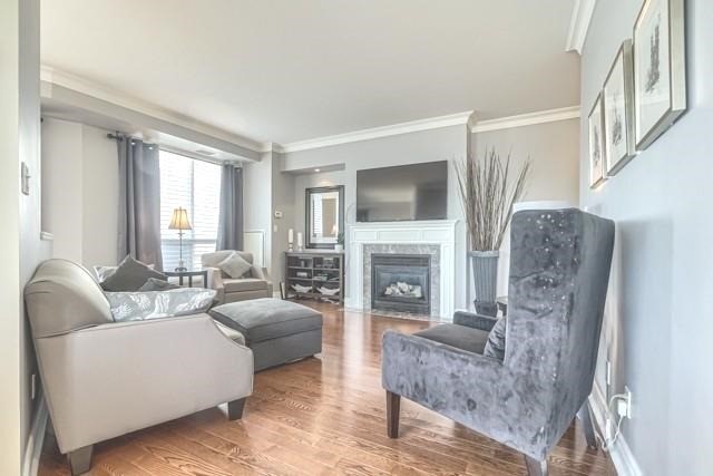 The living room at 1709 - 2111 Lake Shore Blvd W — gas fireplace, hardwood floors and tall windows