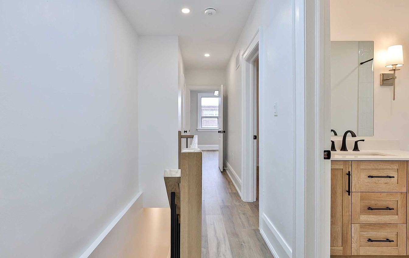 Upper hallway with staircase and renovated bathroom