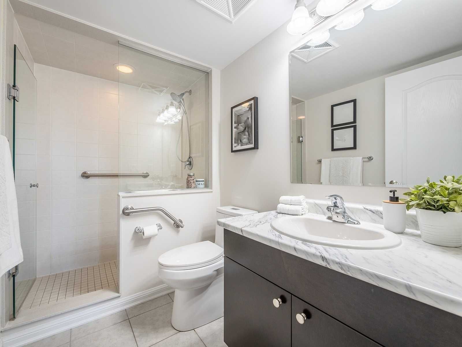 Bathroom with glass shower and marble-look vanity