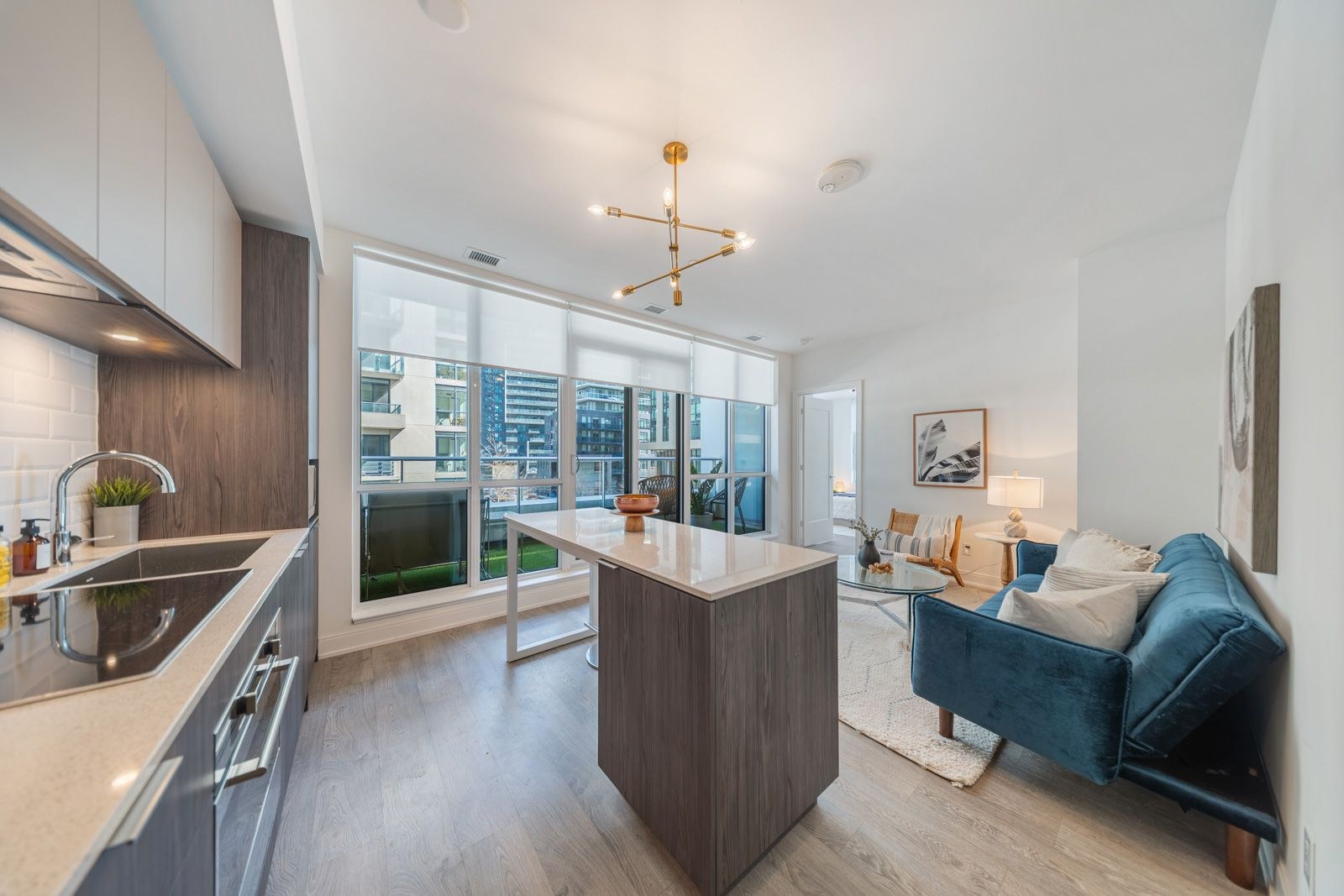 Open-concept kitchen and living room with island and walkout to the terrace at 70 Annie Craig Drive