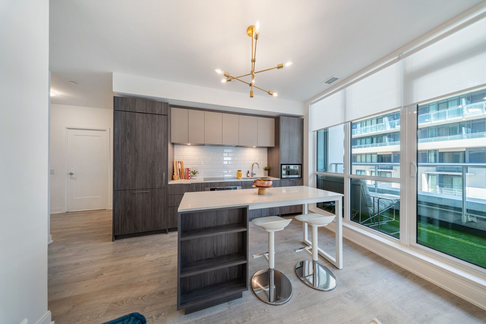 Kitchen island with bar seating and floor-to-ceiling terrace doors