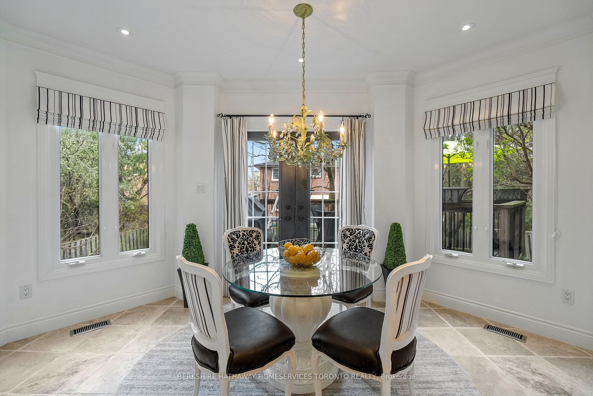 Dining room with chandelier and French doors opening to the backyard deck at 79 Larkin Avenue
