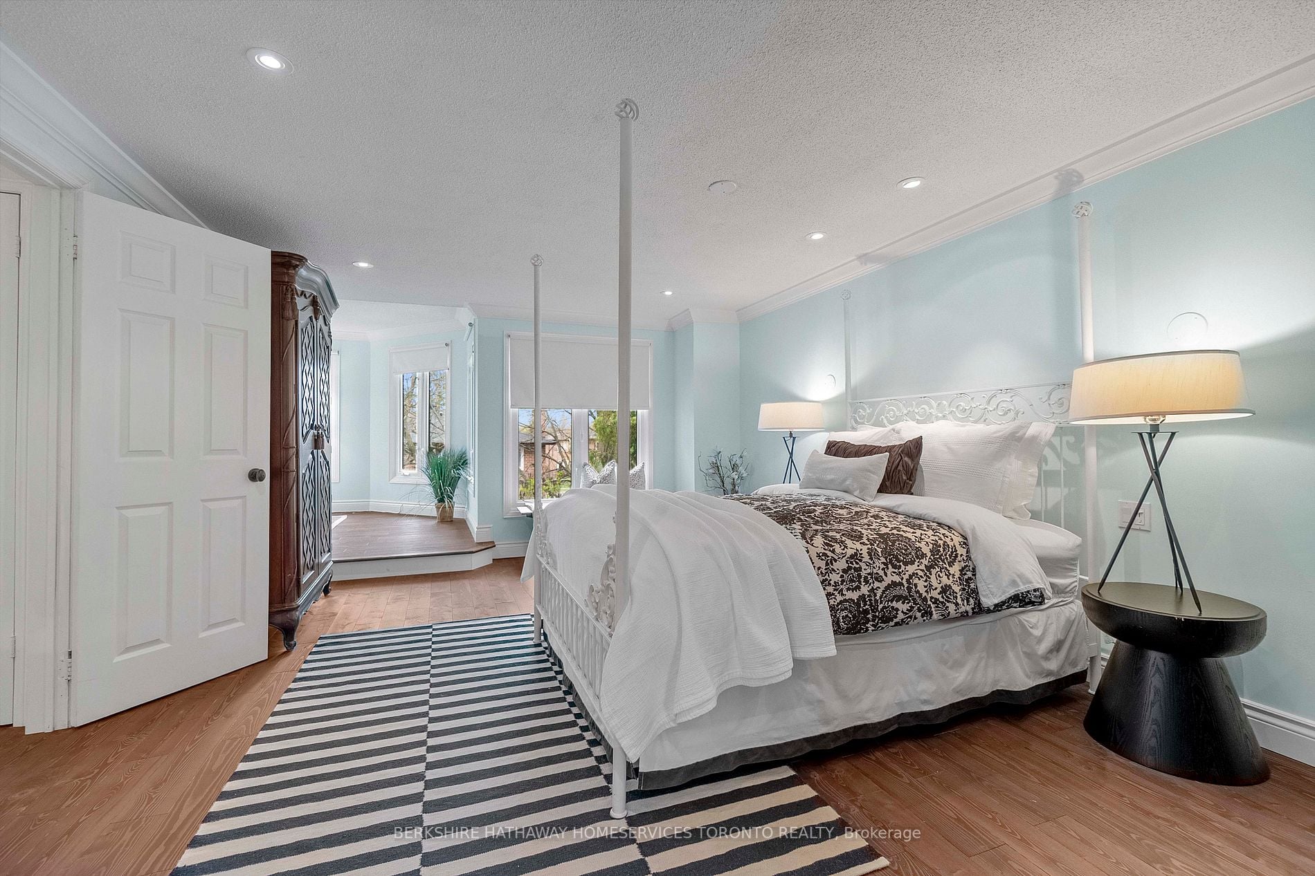 Primary bedroom with four-poster bed and bay-window sitting nook