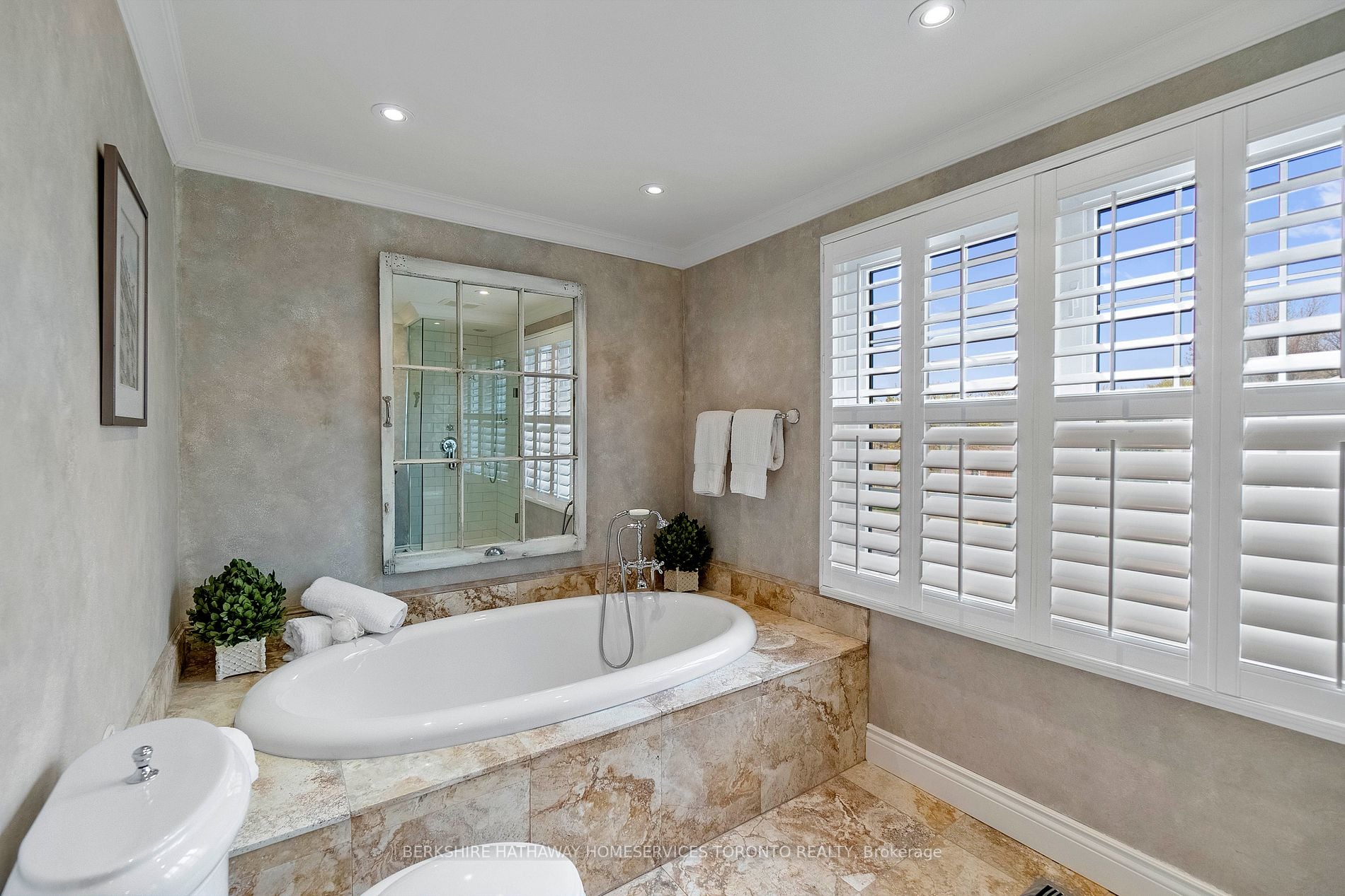 Primary ensuite with marble soaker tub and plantation shutters