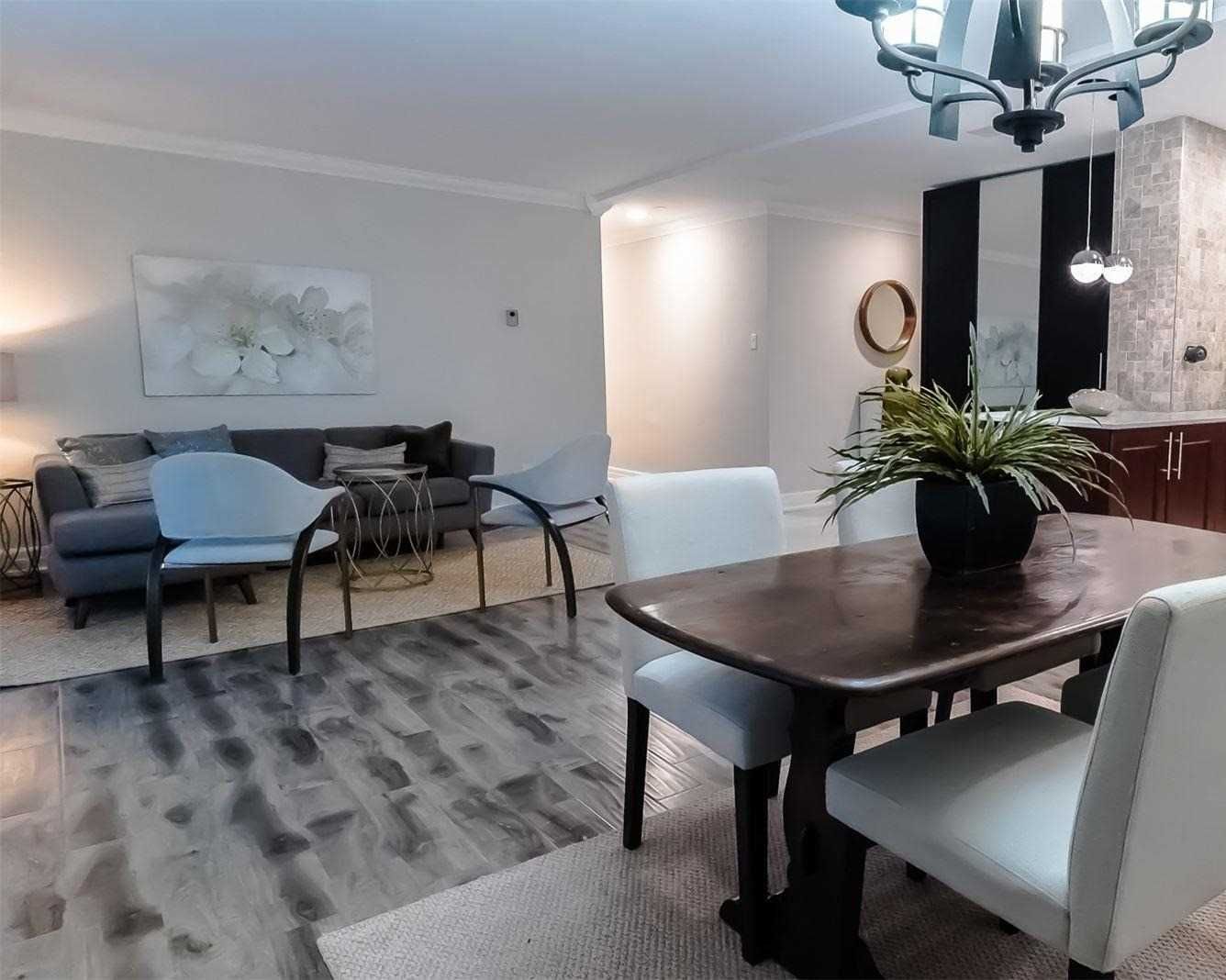 Living room with grey sofa, dining table and chandelier