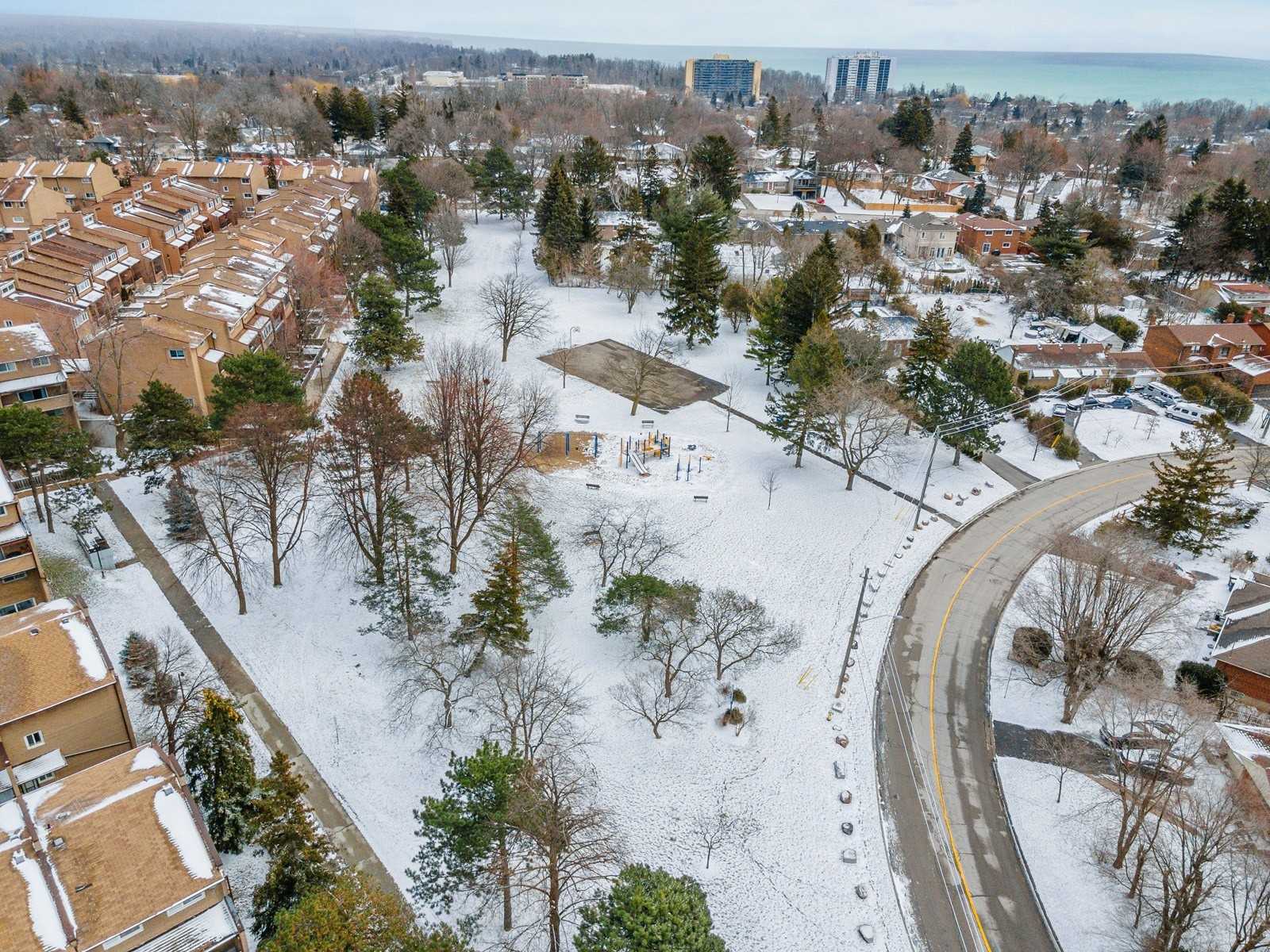 Aerial view of the Scarborough Golf Club Road Townhouses beside a park, with Lake Ontario on the horizon